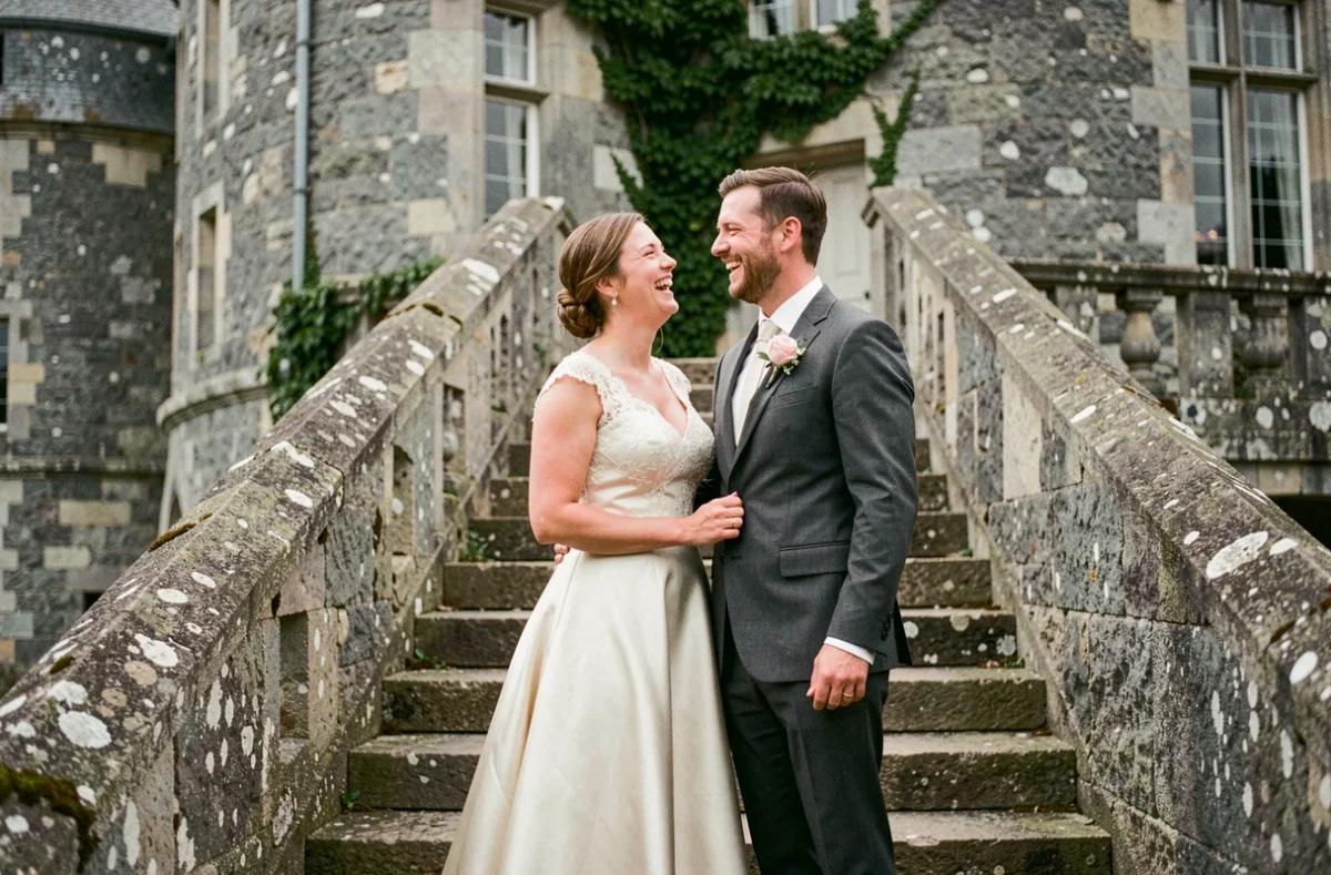 Couple de mariés photographié devant le château de Combourg lors de leur mariage, rendu avec un style documentaire naturel